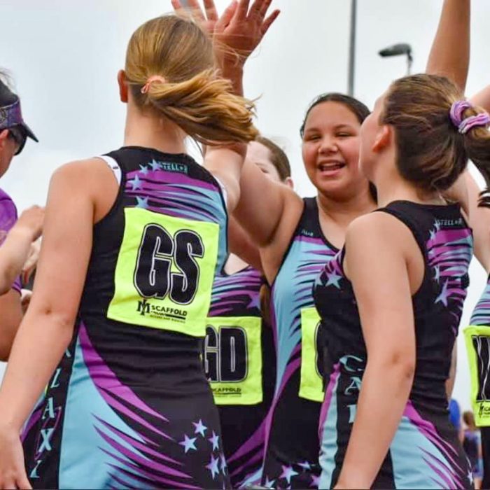 Galaxy Netball Club Players high fiving on Court during Game